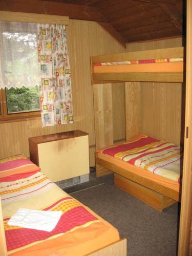 a room with two bunk beds and a window at Chaty u Loveckého zámečku in Buchlovice
