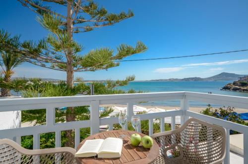 a table on a balcony with a view of the beach at Prestige on the beach in Naxos Chora