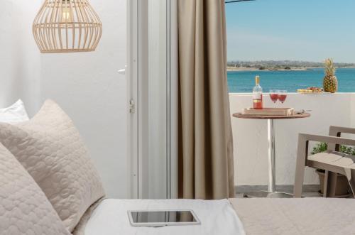 a bedroom with a bed with a view of the ocean at Prestige on the beach in Naxos Chora