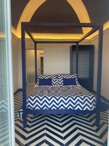 a bedroom with a bed with a blue canopy at Imperati Suites by Alcione Residence in Positano