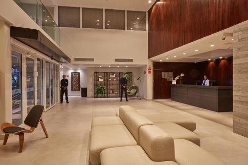 a lobby of a building with a couch and chairs at Flix Hotel in Maceió