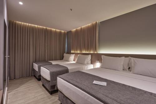 a hotel room with two beds and curtains at Flix Hotel in Maceió