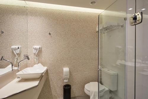 a bathroom with a toilet and a sink and a shower at Flix Hotel in Maceió