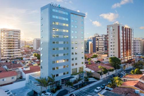 a tall white building in a city with buildings at Flix Hotel in Maceió