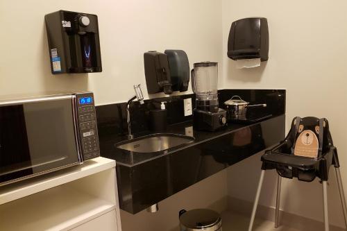 a kitchen with a counter with a sink and a microwave at Flix Hotel in Maceió