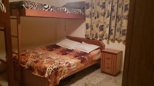 ein Schlafzimmer mit einem Etagenbett und einem Bett mit einem Nachttisch in der Unterkunft Praia Grande - Aviação in Praia Grande