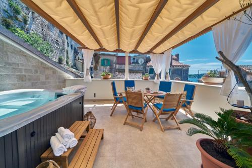 a patio with a tub and a table and chairs at Villa Pergola in Šibenik