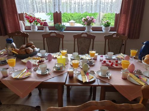 a table with breakfast foods and orange juice on it at Gästehaus zum Georgenberg in Goslar