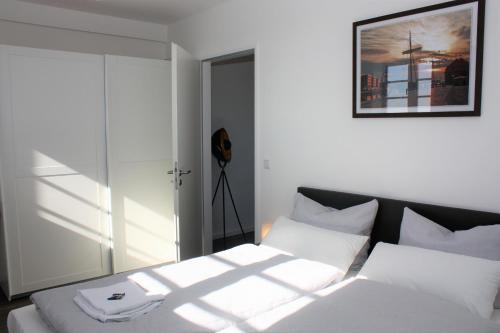 a bedroom with a white bed with white pillows at Appartement Altstadtblick im Ohlerich-Speicher in Wismar