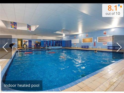 uma grande piscina interior aquecida num edifício em Park Home at Golden Sands Holiday Park em Foryd
