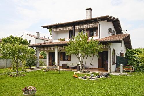a white house with a lawn in front of it at VECCHIA FAVOLA HOUSE in Quarto dʼAltino