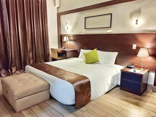 a hotel room with a large bed and a chair at Weston Suites Hotel in Santo Domingo