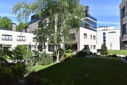 a large building with a green lawn in front of it at Amber - Luxury Two Bedroom Apartment in Palanga