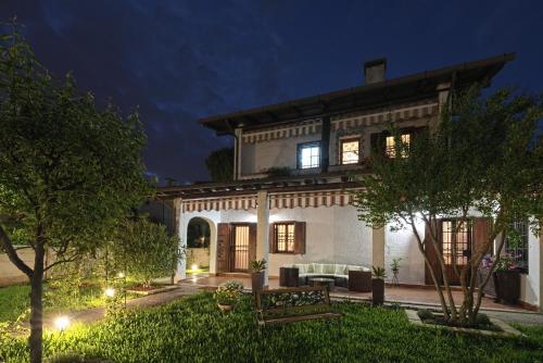 a home with a lit up yard at night at VECCHIA FAVOLA HOUSE in Quarto dʼAltino