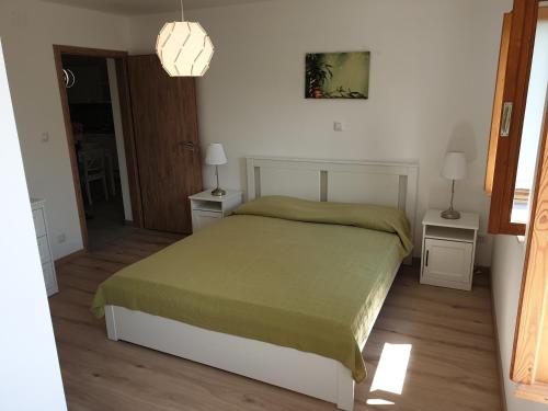 a bedroom with a bed and two tables and a lamp at Apartments Stella Apsyrtides in Osor