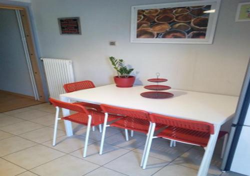 a white table with red chairs in a room at Karditsa Home Sweet Home 80 τ.μ in Kardítsa