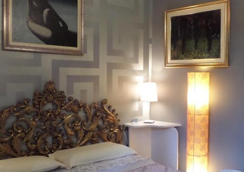 a bedroom with a bed and a lamp and a picture at La Finestra sul Fiume in Fossombrone