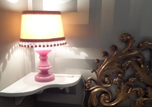 a pink lamp sitting on a table next to a mirror at La Finestra sul Fiume in Fossombrone