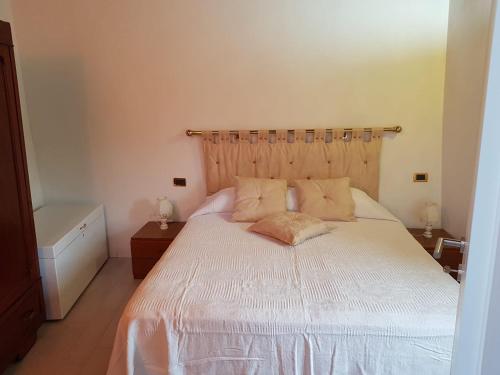 een slaapkamer met een wit bed en een houten hoofdeinde bij Luciano & Norma's House La Torre in Massa Marittima