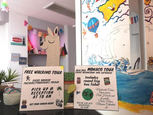 a sign for a free walking tour and a poster of a donkey at Meyerbeer Beach in Nice