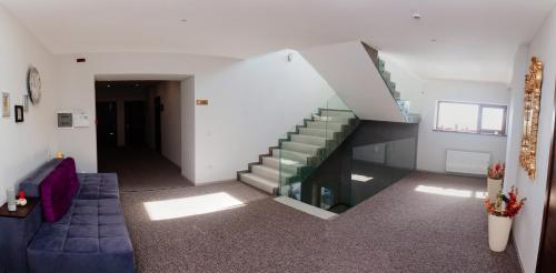 a living room with a staircase and a blue couch at ART Boutique Chalet in Yanoshi