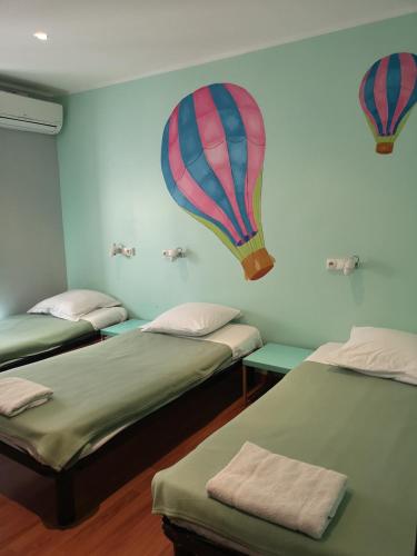 a room with three beds with a hot air balloon on the wall at Meyerbeer Beach in Nice