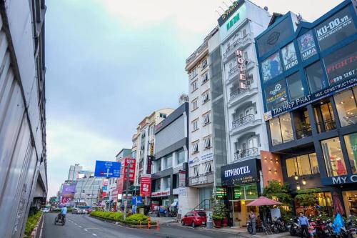 uma movimentada rua da cidade com muitos edifícios e carros em H79 HOTEL em Cidade de Ho Chi Minh