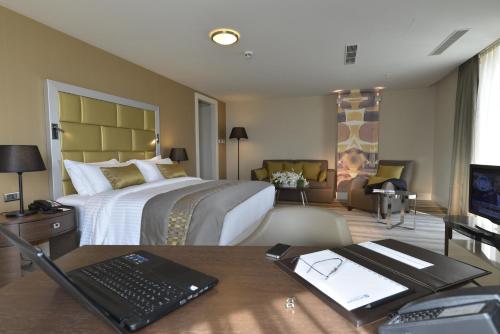 a hotel room with a bed and a desk with a laptop at Wyndham Grand Istanbul Europe in Istanbul
