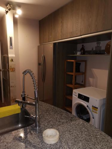 a kitchen with a sink and a washing machine at Los corzos in Burgohondo