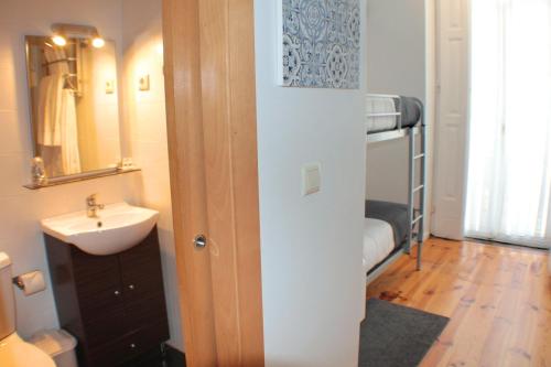 bagno con lavandino, servizi igienici e specchio di Dear Porto Guest House a Porto