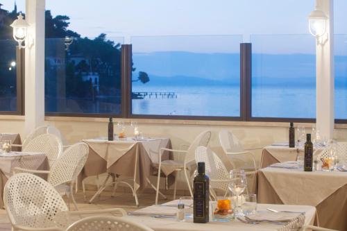 a dining room table with chairs and umbrellas at Baia D'Argento in Porto Santo Stefano