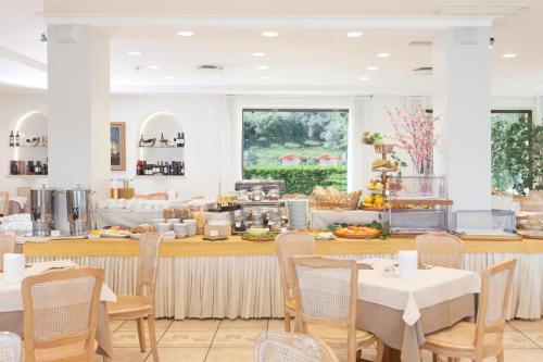 a restaurant with tables and chairs and a buffet at Baia D'Argento in Porto Santo Stefano