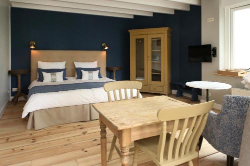 1 dormitorio con 1 cama, mesa y sillas en Bed and Breakfast Het Dijkhuis Eersel, en Eersel