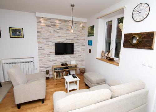 een woonkamer met een bank en stoelen en een tv bij House 4 Rent Laura in Mali Lošinj