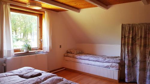 a bedroom with two beds and a window at Sænehus Husmandssted in Allinge