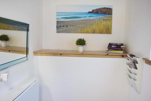 a living room with a shelf and a painting on the wall at Flat 14d Bayhead in Stornoway