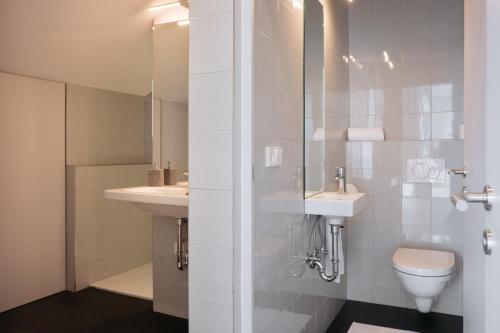 La salle de bains est pourvue de 2 lavabos, de toilettes et d'une douche. dans l'établissement Appartement Hell, à Dobbiaco