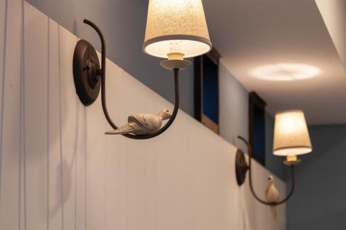 a bird is sitting on a light on a wall at Rambling Snail in Luodong