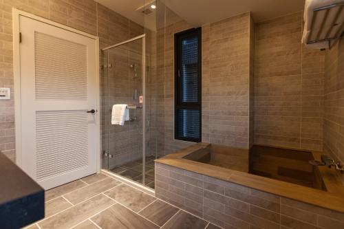 a bathroom with a tub and a shower at Rambling Snail in Luodong