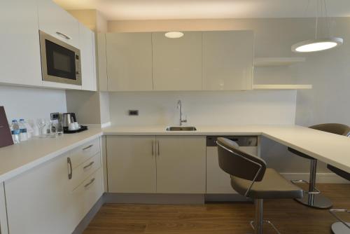 a kitchen with white cabinets and a table and chairs at Wyndham Grand Istanbul Europe in Istanbul