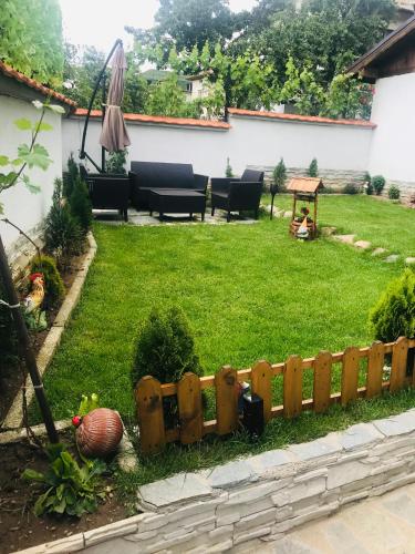 a backyard with a wooden fence in the grass at Guest house Grahlyov in Sapareva Banya