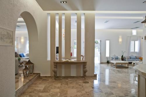 a living room with a table in the middle of a room at Kamari Hotel in Platis Yialos Mykonos