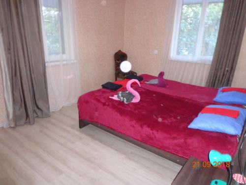 a bedroom with a bed with a red blanket at My home udabno in Udabno