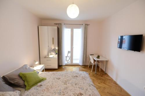 biała sypialnia z łóżkiem i biurkiem w obiekcie Apartment Rocky I w mieście Zadar