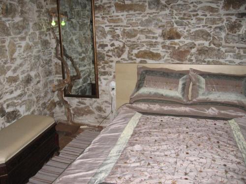 a bedroom with a bed and a stone wall at SAMOS 1880 in Marathokampos