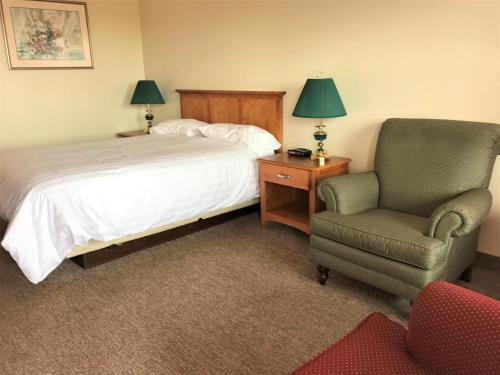a bedroom with a bed and a chair and a desk at Hopewell Rocks Motel & Country Inn in Hopewell Cape