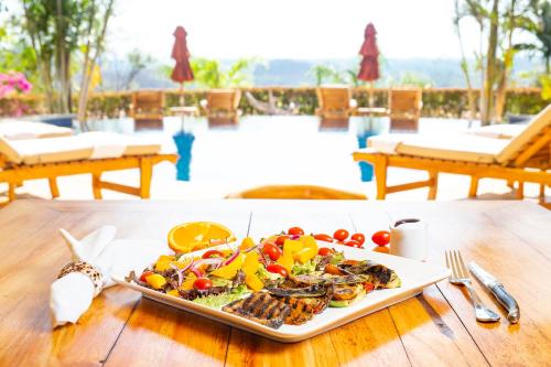 a plate of food on top of a wooden table at Los Altos de Eros - Adults Only in Playa Avellana