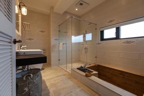 a bathroom with a sink and a glass shower at Rambling Snail in Luodong