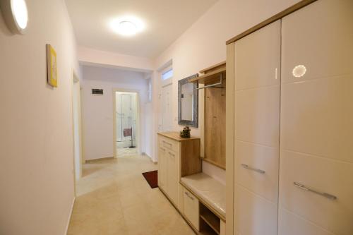 korytarz z białymi szafkami i telewizorem w domu w obiekcie Apartment Rocky I w mieście Zadar