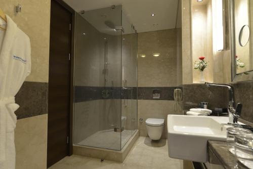 a bathroom with a shower and a sink and a toilet at Wyndham Grand Istanbul Europe in Istanbul